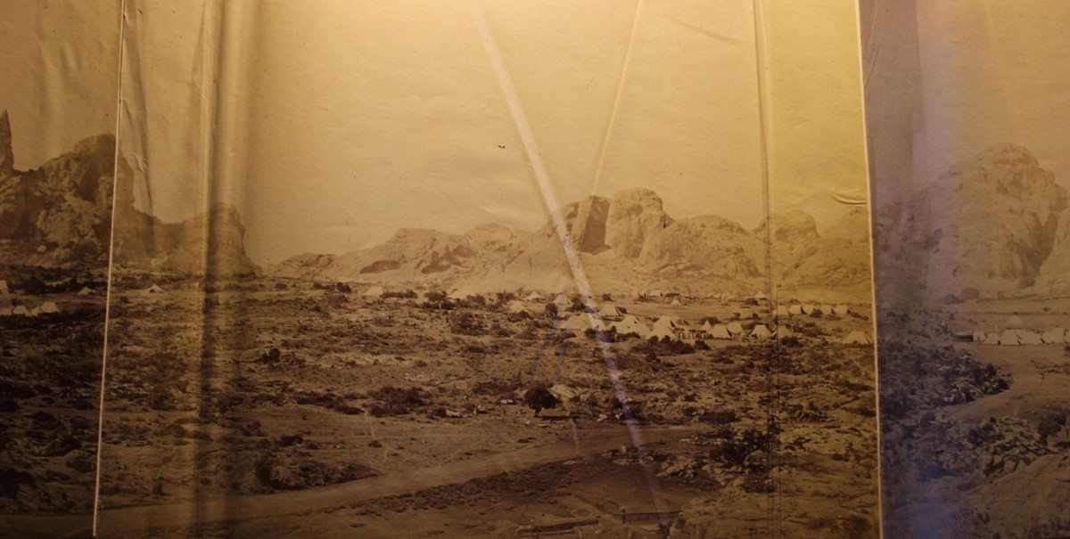 photo of tents in an area of scrubland overshadowed by huge rocky outcrops