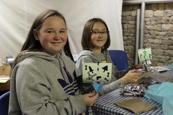 Photo of two girls with pirate ships made in a museum craft session.