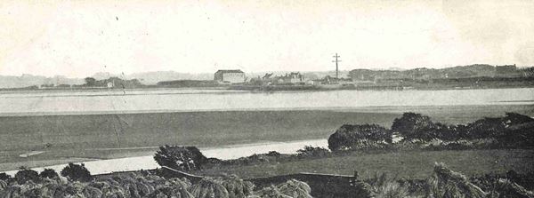 The black and white photo shows Glasson across the River Lune from fields at Overton.