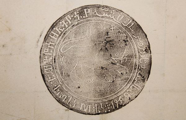 photo of a circular ink stamp with text around the edges and an image of a crowned lion in the centre.