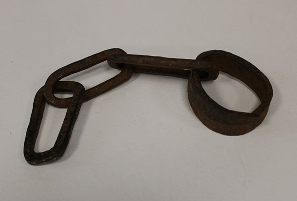 photo of an iron manacle attached to a short chain.